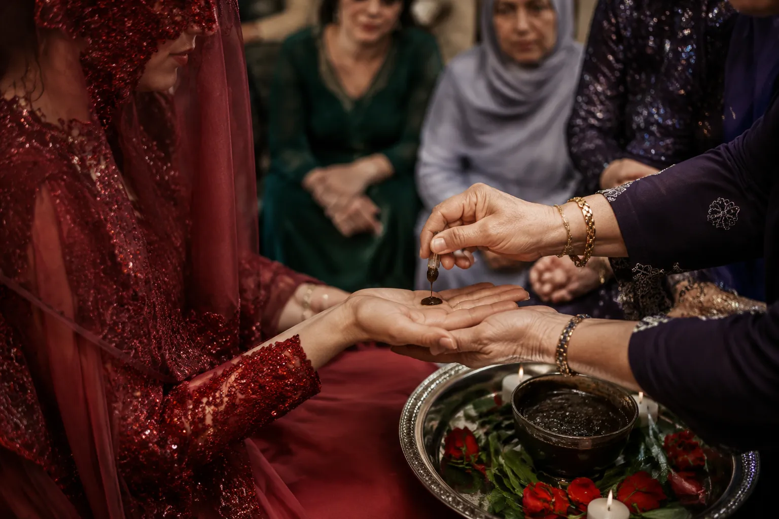 Henna being placed in a bride's palm during a farewell ceremony