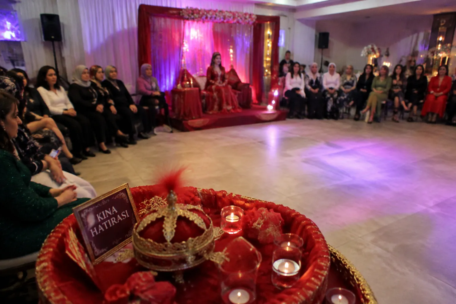 Modern kina gecesi ceremony setting with henna tray, family seating, and dance area